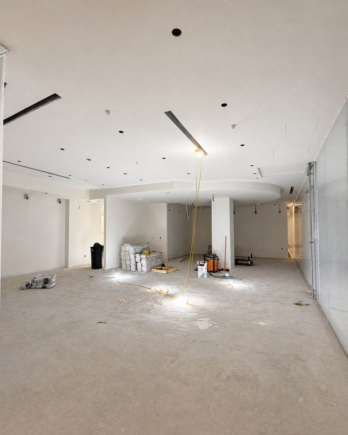 Open Shifeon commercial interior during early construction with an unfinished concrete floor and ceiling openings.